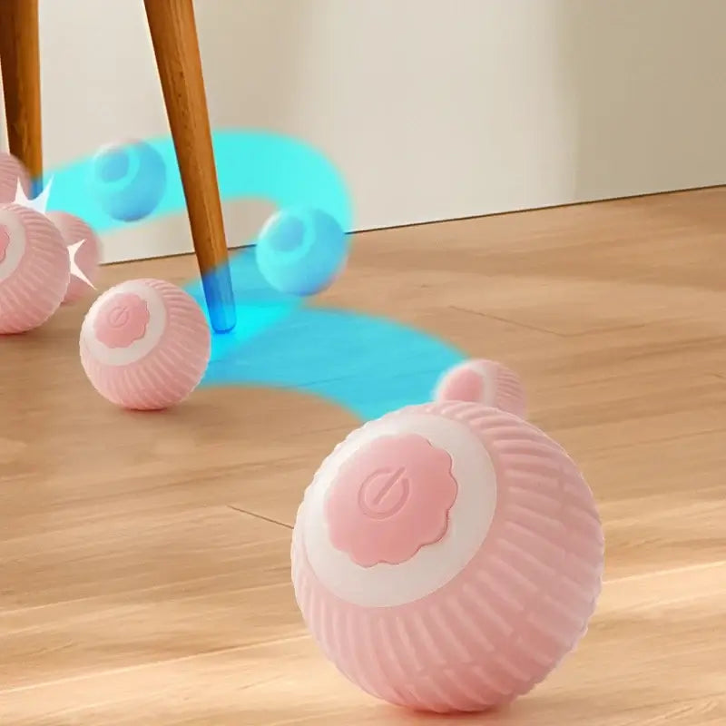 Interactive auto-rolling toy for pets in pink, rolling on a wooden floor with motion effects.